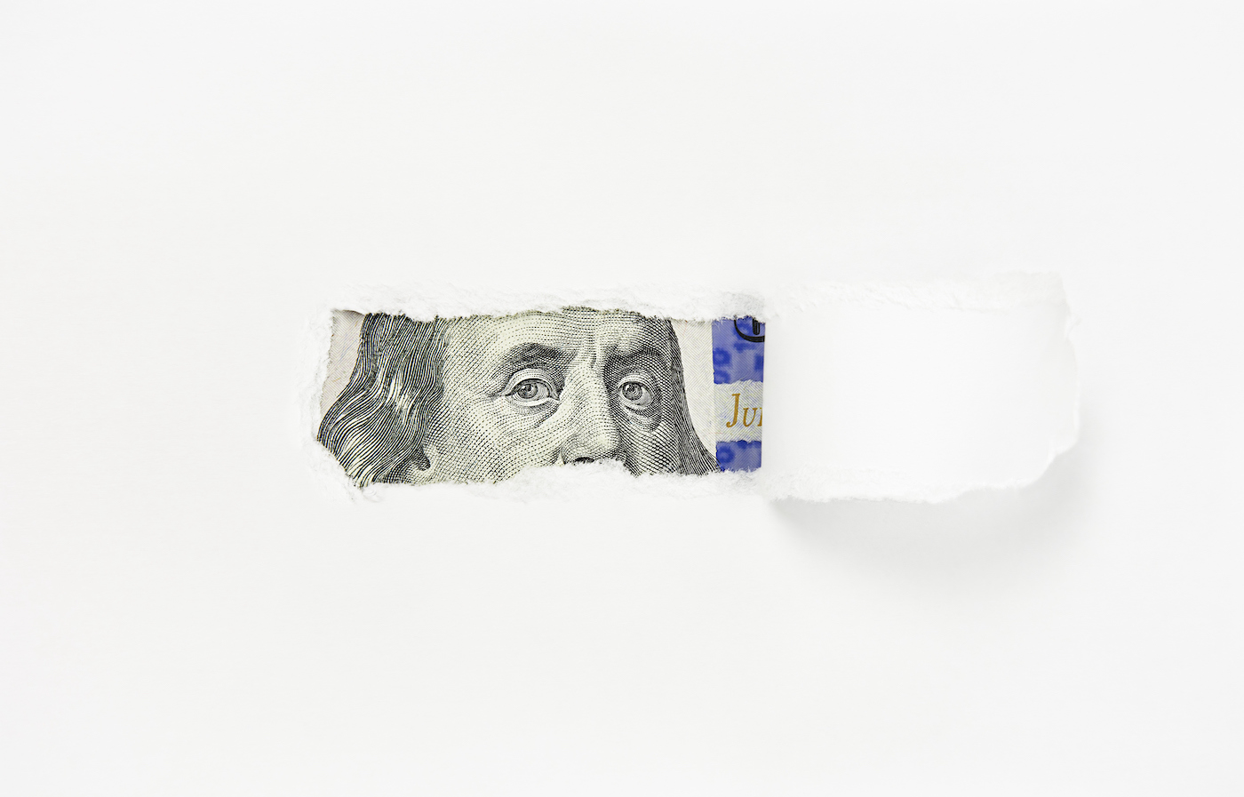 Retrato de Benjamin Franklin en un billete de cien dólares en un agujero de papel rasgado, primer plano