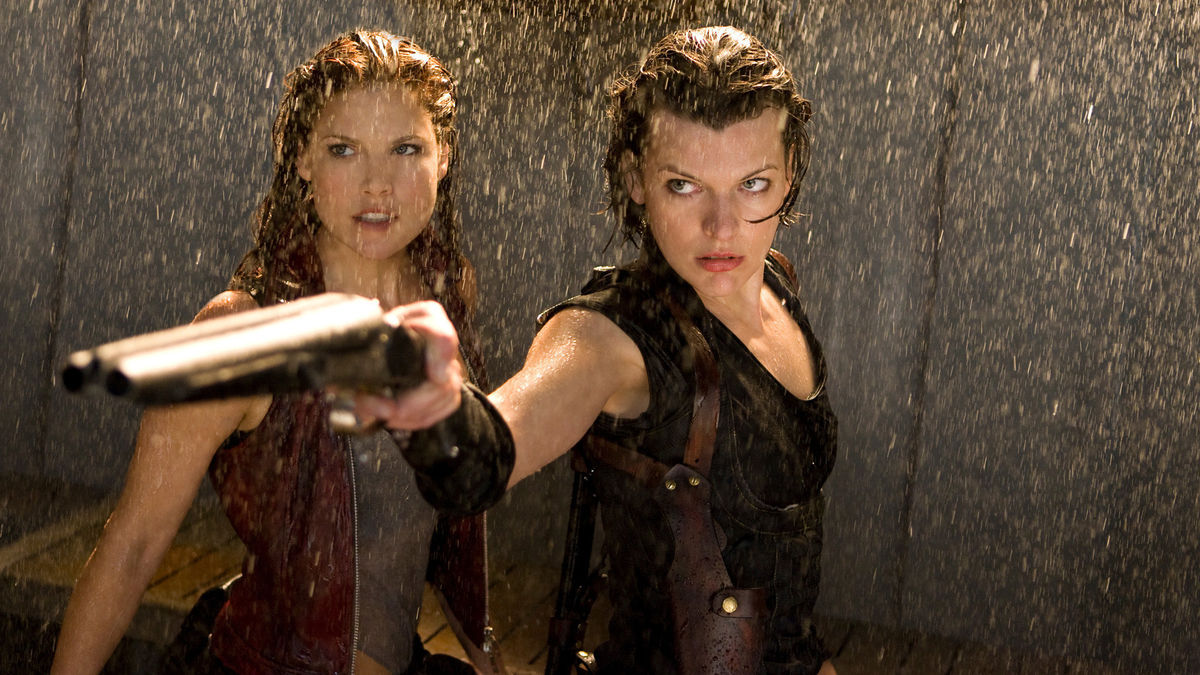 Milla Jovovich apunta con una escopeta y se para con Ali Larter bajo el agua que cae en Resident Evil: Afterlife