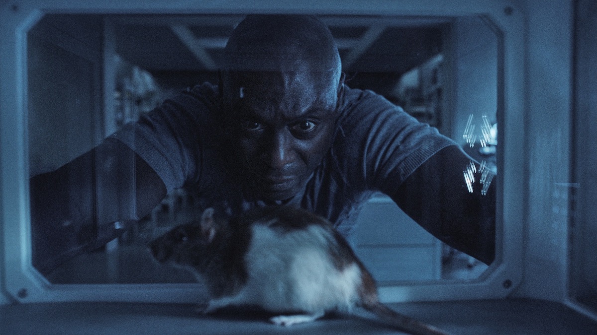 Lance Reddick mira a una rata en una jaula en Resident Evil