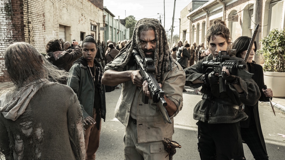 Khary Payton como Ezekiel, Nadia Hilker como Magna y Angel Theory como Kelly, armados, en el final de la serie The Walking Dead